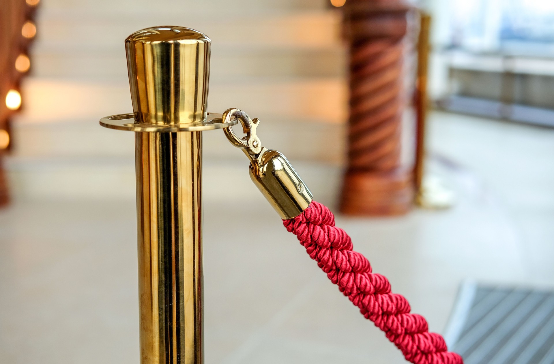 Close-up of an old-colored barrier with red cord in a luxurious foyer